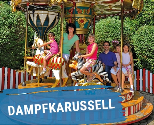 Dampfkarussell mit mehreren Personen, die auf bunten Pferden sitzen.