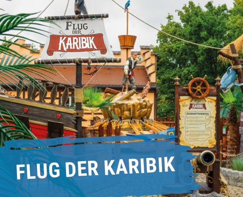 Fahrgeschäft namens Flug der Karibik mit bunten Booten und Kindern, die darin sitzen und Spaß haben.