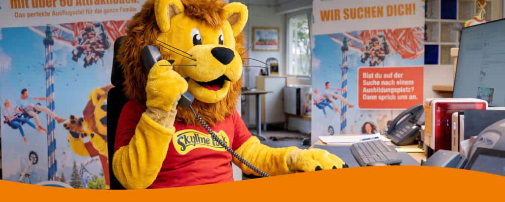 Das Löwenmaskottchen Löwe vom Skyline Park im Büro als Kontakt
