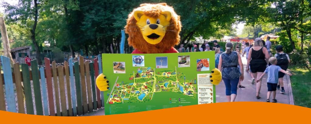 Löwenmaskottchen Löwe vom Allgäu Skyline Park hält den Parkplan in den Händen