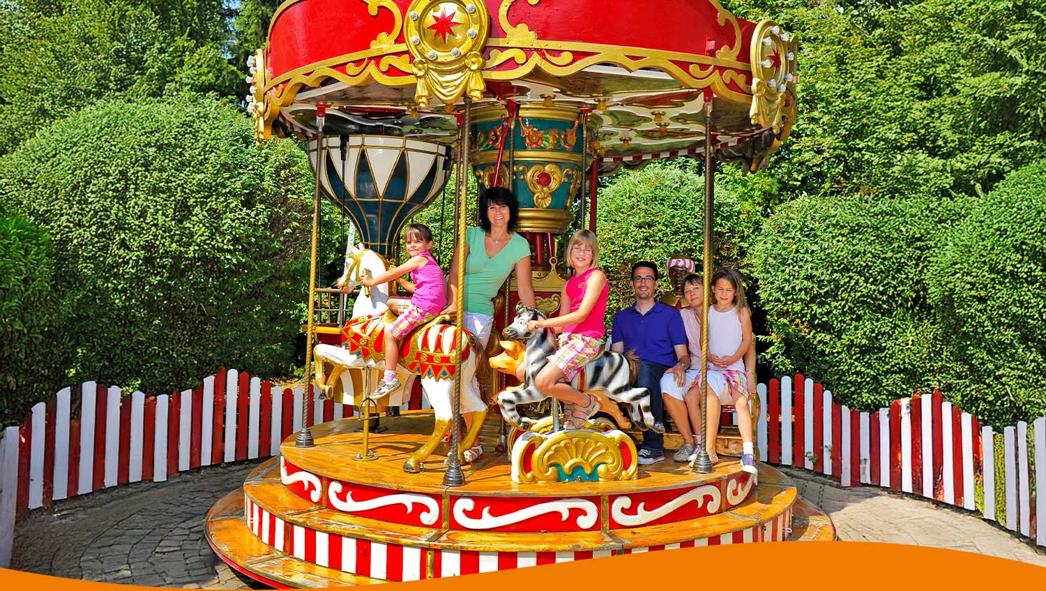 Dampfkarussell mit mehreren Personen, die auf Pferden sitzen, im Freizeitpark.