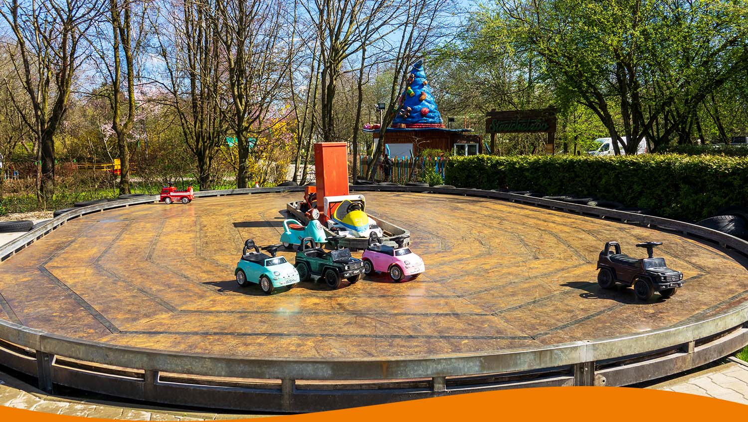 Miniaturfahrzeuge auf einem runden Fahrkurs in einem Freizeitpark.