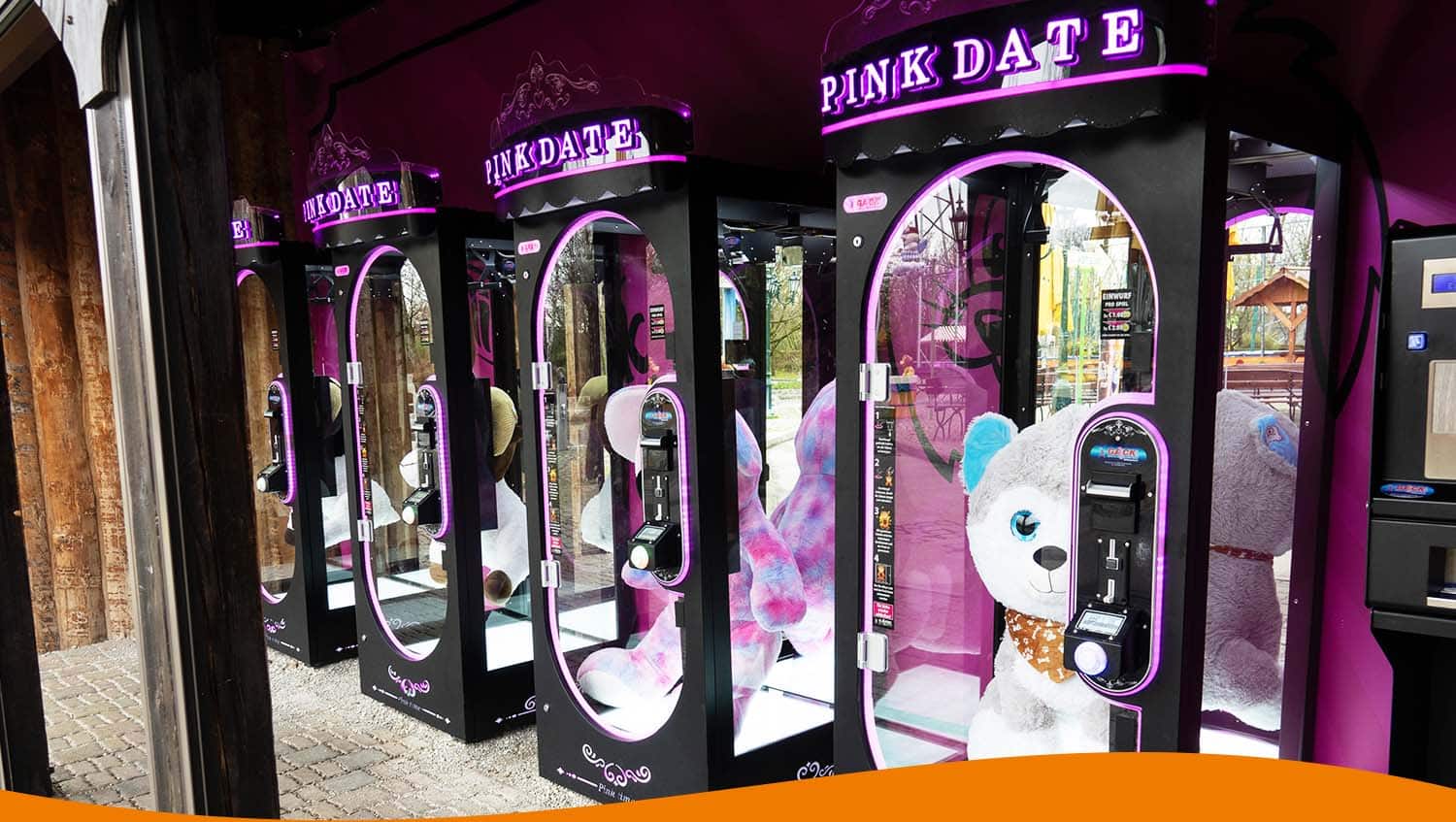 Verschiedene Automaten für Plüschtiere in einem Freizeitpark mit bunten Stofftieren.