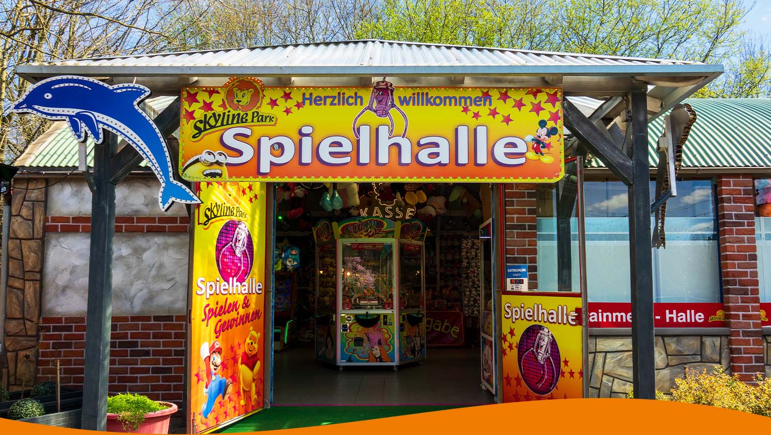 Bunt gestalteter Eingang zur Spielhalle im Skyline Park mit einem Delfin-Symbol.