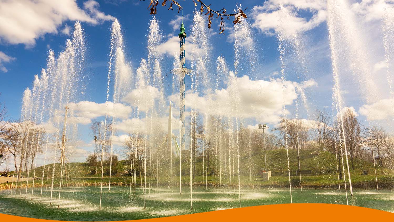 Wasserfontänen spritzen in die Luft vor einem klaren blauen Himmel mit Wolken.
