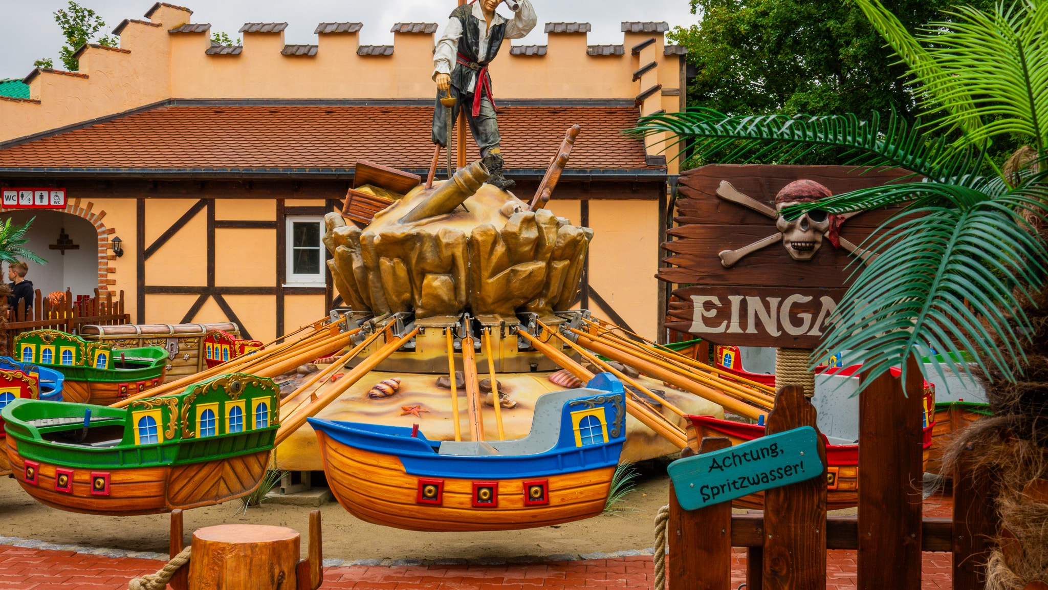 Karussell mit bunten Piratenschiffen, auf dem Kinder spielen und sich drehen.