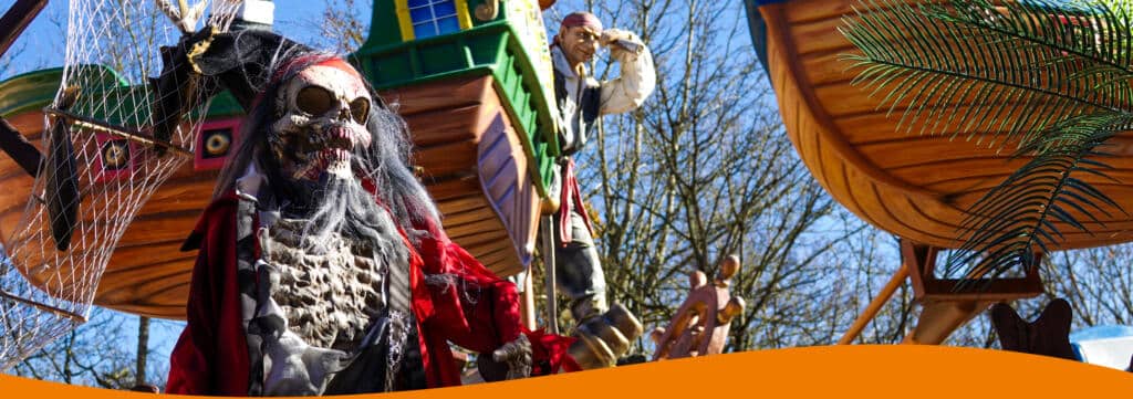 Piratenthemen-Karussell mit mehreren bunten Booten und Kindern, die darauf sitzen, im Freizeitpark.