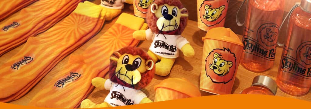 Mehrere Souvenirs in Lewis Schnick Schnack Shop im Allgäu Skyline Park ein Löwe Plüschfigürchen Plüsch Becher und Socken