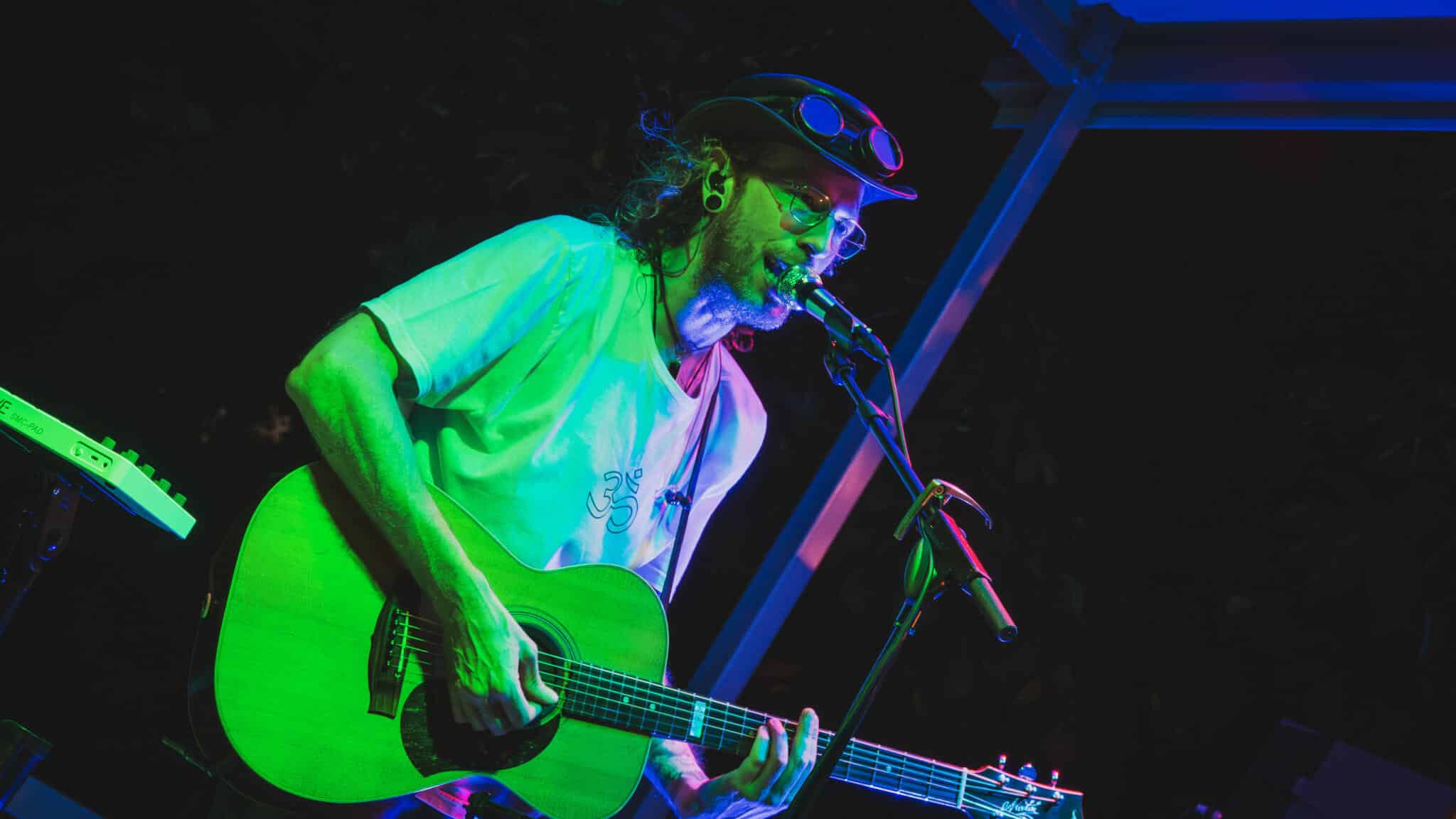 Ein Mann mit Gitarre in buntem Licht an Skyline Park bei Nacht