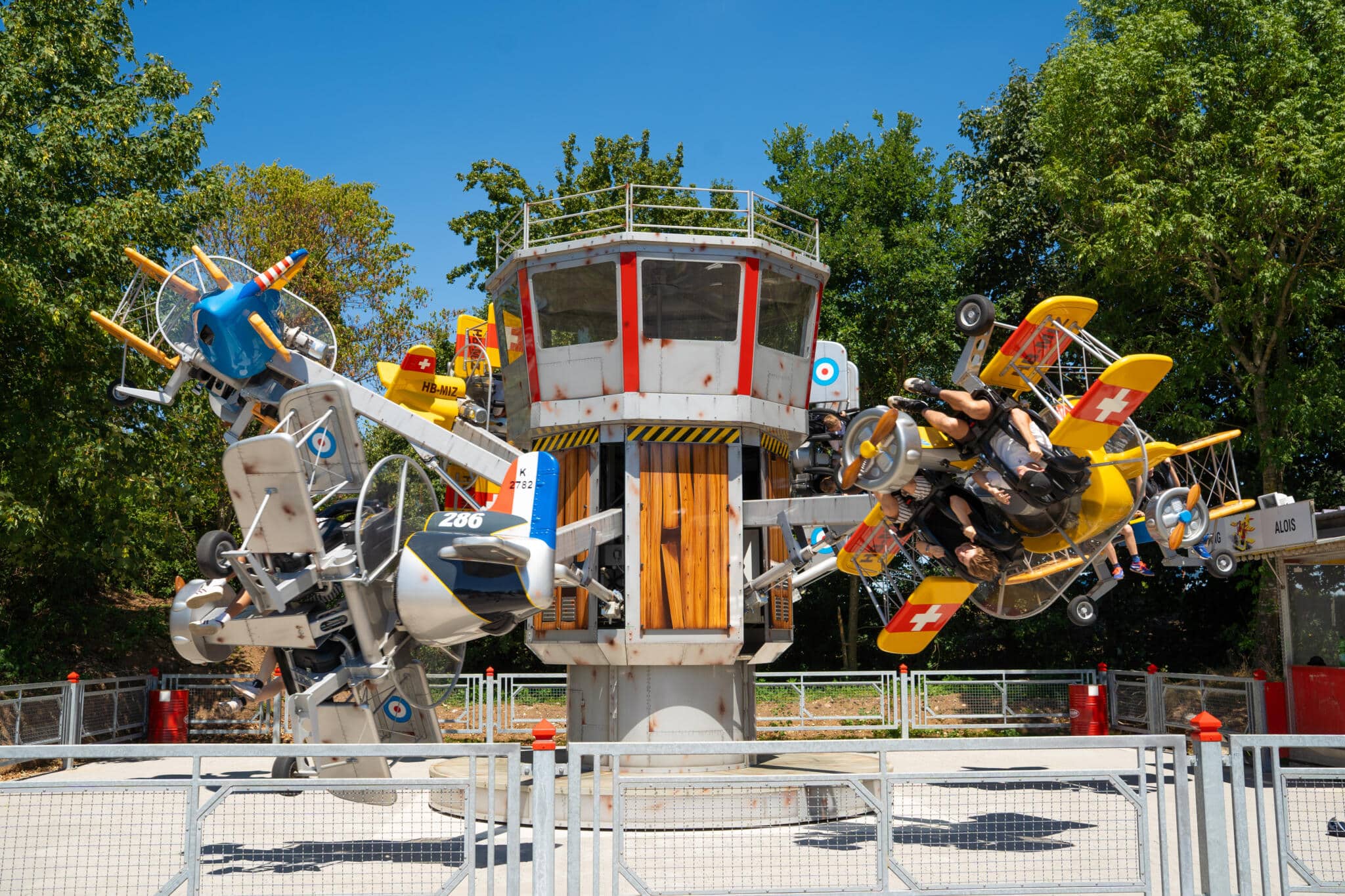 Flugzeugkarussell mit gelben und blauen Flugzeugen, das sich um eine zentrale Säule dreht.