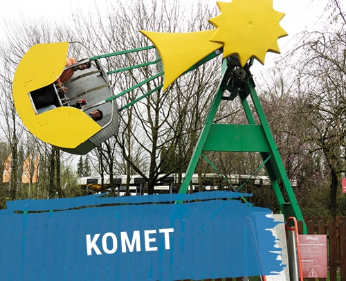 Gelbe Fahrgeschäfte mit einer Kometenform, die in einem Freizeitpark installiert sind.