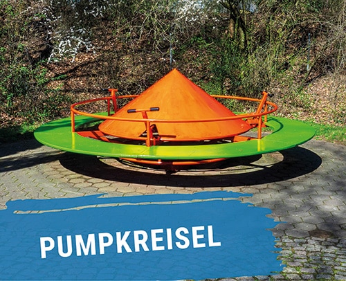 Buntes Pumpkreisel-Spielgerät mit orangefarbener Spitze und grüner Basis in einem Spielplatzbereich.