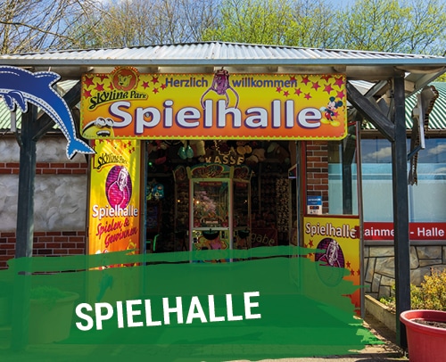 Eingang zur Spielhalle mit bunten Schildern und Spielen im Skyline Park.