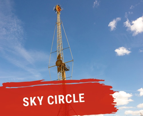 Sky Circle Attraktion mit einem hohen Turm und rot-weißer Beschriftung auf einem blauen Himmel.