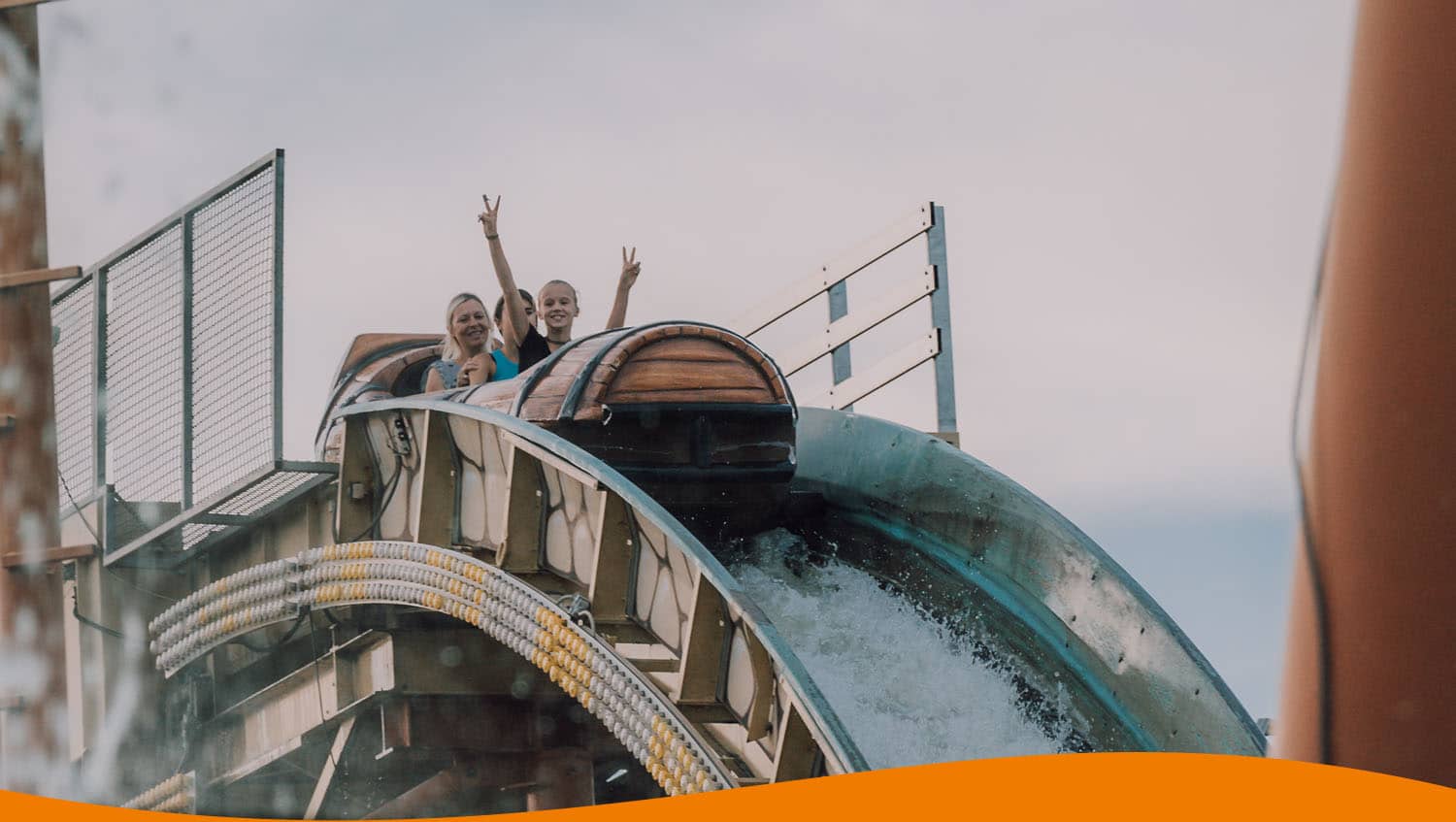Zwei Personen auf einer Wildwasserbahn, die in einem Wasserkanal hinunterfahren.